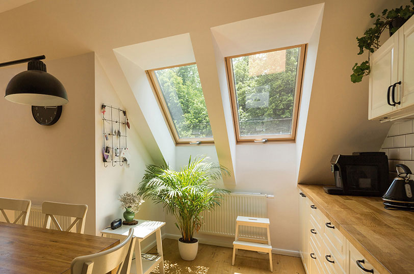two FAKRO windows side by side in a modern kitchen with light oak counter tops and house plants