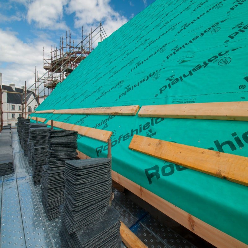 A breather membrane being installed on a construction site.